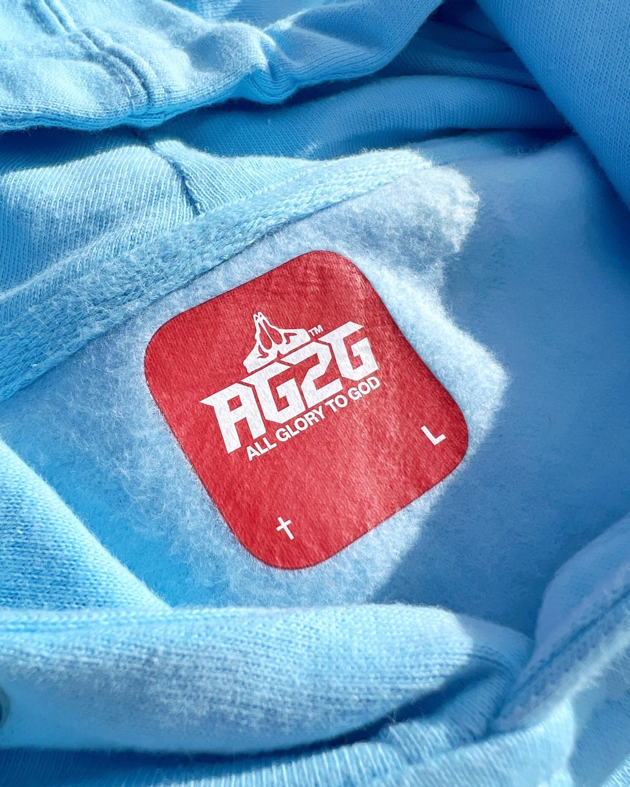 Christian Apparel: All Glory To God ‘Essential’ Hoodie in Sky Blue featuring bold lettering. Perfect for Christian hoodies, Christian streetwear, and Christian athletic wear fans seeking faith-inspired style and comfort.
